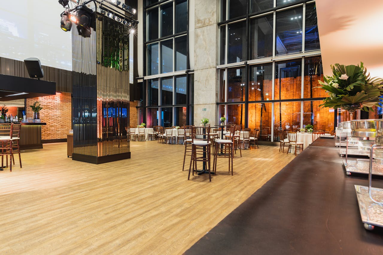 A modern and stylish event hall, ready for a banquet or celebration, featuring large windows and contemporary decor.